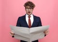 Shocked young man in suit reading newspaper Royalty Free Stock Photo