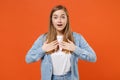 Shocked young woman girl in casual denim clothes posing isolated on bright orange wall background studio portrait Royalty Free Stock Photo