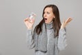 Shocked young woman in gray sweater, scarf spreading hands, holding daily pill box isolated on grey background. Healthy Royalty Free Stock Photo