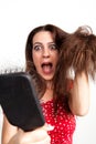 Shocked young woman with hair brush