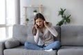 Shocked young woman hearing unexpected bad news, talking on phone Royalty Free Stock Photo