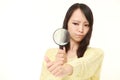 Shocked young woman looking through a magnifying glass her nails Royalty Free Stock Photo