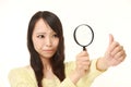 Shocked young woman looking through a magnifying glass her nails Royalty Free Stock Photo