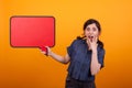 Shocked young woman with a speech bubble against a yellow background in studio Royalty Free Stock Photo