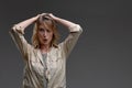 Shocking news. Millennial caucasian woman holding her head with both hands, exclaiming shock, grey background Royalty Free Stock Photo