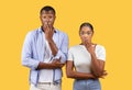 Shocking news. Young black couple man and woman with wide open eyes, covering mouth with hand, yellow background Royalty Free Stock Photo