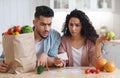 Shocking Prices. Confused Middle Eastern Spouses Checking Bills After Grocery Shopping