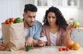 Shocking Prices. Confused Middle Eastern Spouses Checking Bills After Grocery Shopping Royalty Free Stock Photo