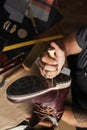 Close up of shoe maker hands producing boots in his leather workshop Royalty Free Stock Photo