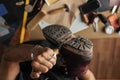 Close up of shoe maker hands producing boots in his leather workshop Royalty Free Stock Photo