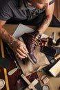 Close up of shoe maker hands producing boots in his leather workshop Royalty Free Stock Photo