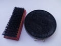 shoe brush made of red wood and black shoe polish Royalty Free Stock Photo