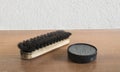 Shoe brush and polish on wooden table Royalty Free Stock Photo