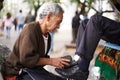 Shoe cleaner, elderly man person and shining feet, small business owner and professional on busy street. Mature, senior Royalty Free Stock Photo