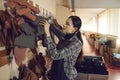 Shoe factory worker looking for the right leather detail among others hanging on peg hanger Royalty Free Stock Photo