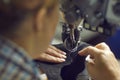 Shoe factory worker making a detail for new footwear on an industrial sewing machine Royalty Free Stock Photo