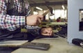 Shoe factory worker sitting at table, making new leather boots and using hand hammer Royalty Free Stock Photo