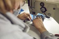 Shoe factory worker using an industrial sewing machine to make a detail for new footwear Royalty Free Stock Photo