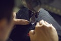 Shoe factory worker using a sewing machine to make a detail for new black sneakers