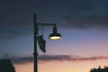 shoe hanging on a street lamp, dusk setting Royalty Free Stock Photo