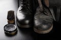 Shoe polish, brush and black military boots. Polishing and cleaning shoes on a black table Royalty Free Stock Photo