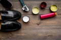 Shoe polish, brushes, wax near black shiny leather shoes on dark wooden background top view copy space Royalty Free Stock Photo