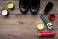 Shoe polish, brushes, wax near black shiny leather shoes on dark wooden background top view copy space Royalty Free Stock Photo