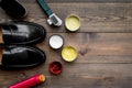 Shoe polish, brushes, wax near black shiny leather shoes on dark wooden background top view copy space Royalty Free Stock Photo