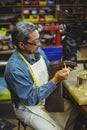 Shoemaker applying glue on shoe