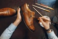 Shoemaker with brush tints shoes, footwear repair