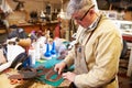 Shoemaker cutting and gluing leather in a workshop Royalty Free Stock Photo