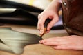 Shoemaker cutting leather in a workshop, close up