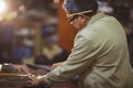 Shoemaker cutting a piece of leather