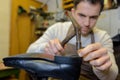 Shoemaker hammering on shoe in workshop Royalty Free Stock Photo
