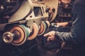 Shoemaker performs shoes in studio craft grinder machine.