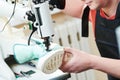 Shoemaker repair shoe. sewing the sole of footwear