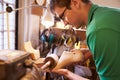 Shoemaker sanding shoe lasts in a workshop