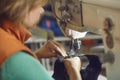 Shoemaker hands in focus sewing leather for making shoe using needle machine