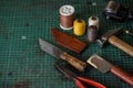 Shoemaker tools laying on cutting and tooling board in workshop. Workplace for shoemaking of handmade shoes. Copy space