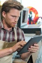 shoemaker using digital tablet in workshop