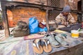 Shoemaker works on the street. The caste system is still intact today but the rules are not as rigid as they were in the past.