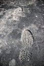 Shoeprint imprinted on gray asphalt.