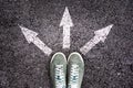 Shoes and arrows pointing in different directions on floor Royalty Free Stock Photo