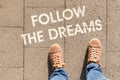 Text FOLLOW YOUR DREAMS on asphalt road