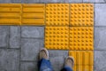 Shoes on block tactile paving for blind handicap Royalty Free Stock Photo