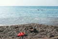 Shoes clogs children's and adult stands on shore sea Royalty Free Stock Photo