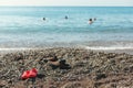 Shoes clogs children's and adult stands on shore sea Royalty Free Stock Photo