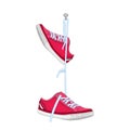 Shoes hanging on nail isolated on white background. Pair of sports footwear hang on peg.