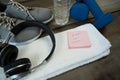 Shoes, headphones, water bottle, towel, dumbbell and stick notes