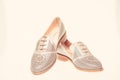 Shoes made out of silver leather on white background, isolated. Footwear for women on flat sole with perforation. Female